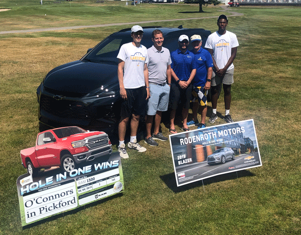 Winner stands next to new car.