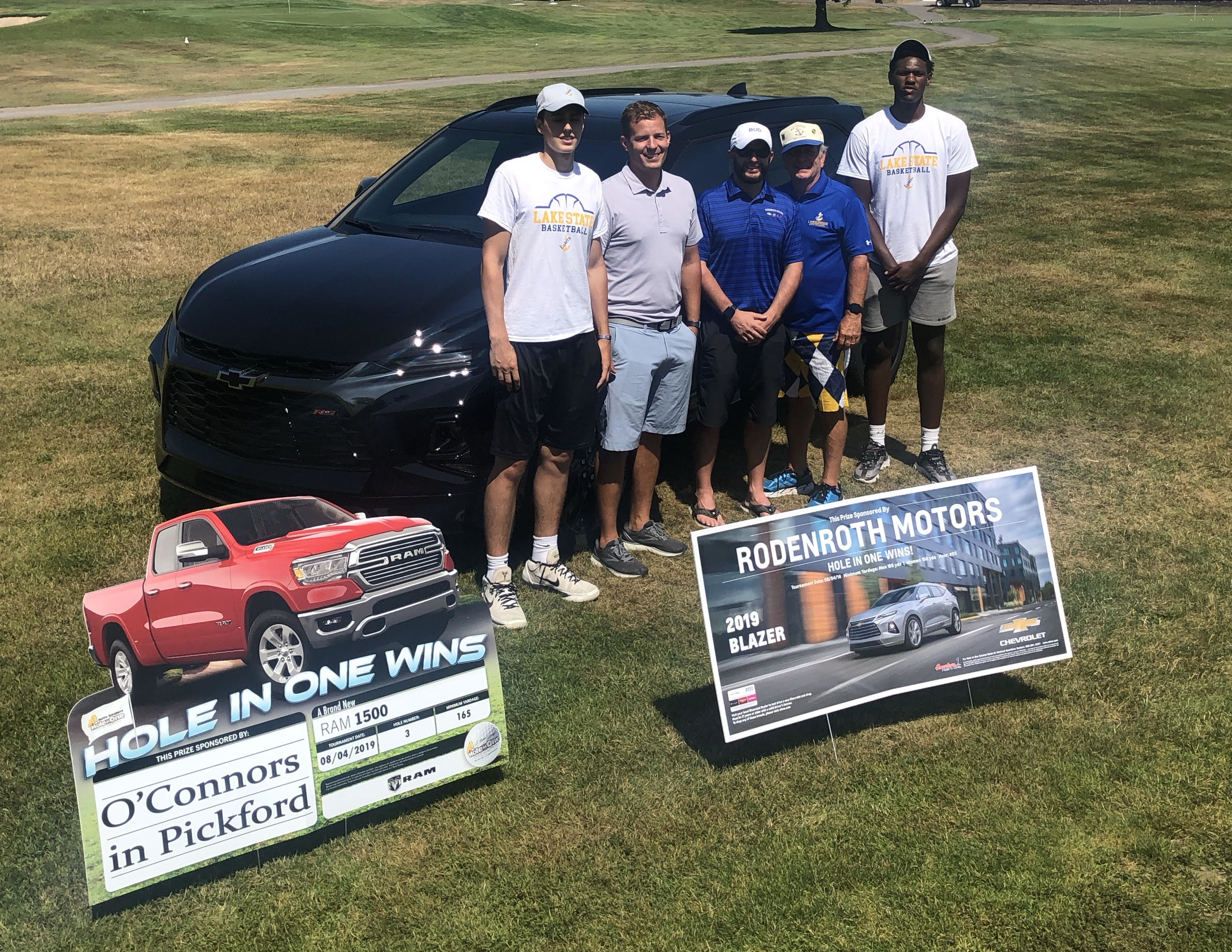 Winner stands next to new car.